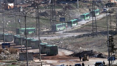 Green government buses carry residents evacuating from eastern Aleppo.