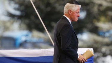 Former US president Bill Clinton passes the flag-draped coffin of former Israeli president Shimon Peres.