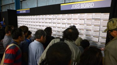 Job seekers browse job notices in Melbourne.