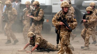 A British trooper falls after being hit by a rock in Basra in 2006.