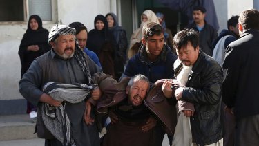 A distraught man is carried after a suicide attack in Kabul, Afghanistan.