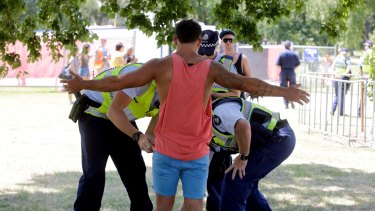 A festival goer is searched for drugs by police. 