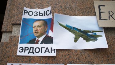 Russian anger: A poster of Turkish President Recep Tayyip Erdogan reading "Wanted Erdogan" left after a protest at the Turkish embassy in Moscow following Turkey's shooting down of a Russian warplane, right, last month.