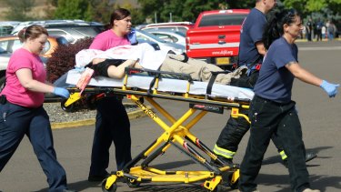Authorities carry a shooting victim away from the scene after a gunman opened fire at Umpqua Community College in Roseburg earlier this month.