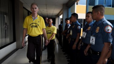 Peter Scully (left) arrives at the Cagayan De Oro court handcuffed to another inmate on his first day of his trial.