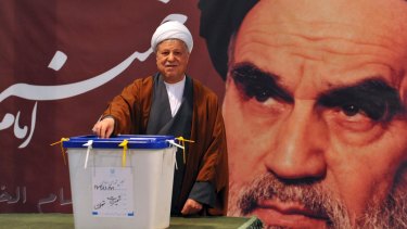 Ali Akbar Hashemi Rafsanjani casts his ballot for parliamentary elections in front of a portrait of  Ayatollah Khomeini in 2012.
