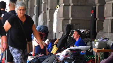 A man sits at the homeless camp outside Flinders Street Station.
