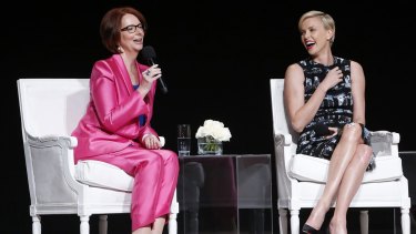 Theron, right, laughs as Ms Gillard speaks during the panel discussion at the Apollo Theater.