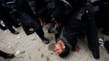 A migrant collapses from exhaustion next to Croatian police officers close to the border with Serbia.
