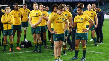 Down and out: Wallabies captain Michael Hooper (front left), Will Genia (front right) and the Wallabies come to terms with defeat against Scotland.