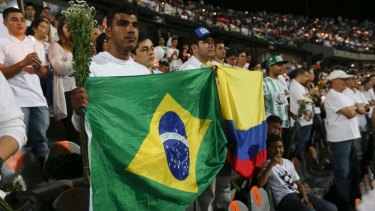 Fans of Colombia's Atletico Nacional soccer team hold flags from Brazil and Colombia during a tribute to Chapecoense where the teams were to face each other in Medellin, Colombia.
