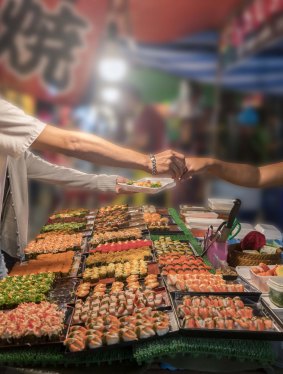 Buying sushi at a local market stall.
