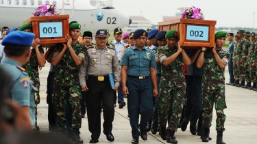 Indonesian soldiers carry coffins containing victims of the AirAsia crash at the Indonesian Air Force Military Base, Surabaya.