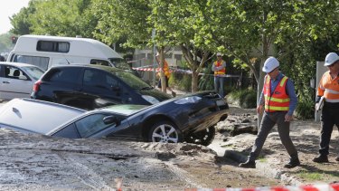 Cars swallowed by a sinkhole caused by flooding in Port Melbourne.