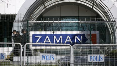 Riot police officers walk by the headquarters of Zaman newspaper in Istanbul after it was shut down.