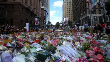 Respectful quiet: People stop to place flowers at Martin Place.