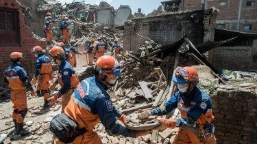 A Japanese disaster relief team remove debris from a collapsed building.