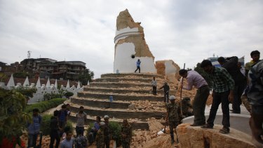 Volunteers work to remove debris at Dharahara Tower following the earthquake in Kathmandu, Nepal, on April 25.