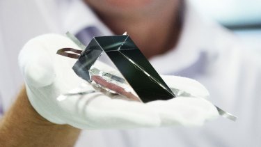 UNSW's Mark Keevers holds a new solar cell that has broken a record for energy efficiency for unfocused light