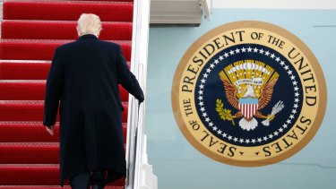 US President Donald Trump walks up the steps of Air Force One.