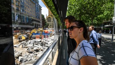 Passersby watch as the City Square site is excavated to make way for  the underground Town Hall Station.