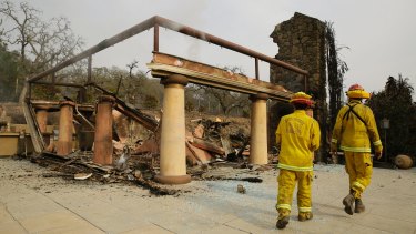 A pair of Napa County firefighters walk through the remains of the Signorello Estate winery on Tuesday.