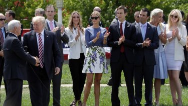 Donald Trump shakes now Vice-President Mike Pence's hands as his sons Eric, daughter-in-law Lara Yunaska, daughter Ivanka, Ivanka's husband Jarred Kushner, son Donald jnr and wife Vanessa, and daughter Tiffany look on during the campaign.
