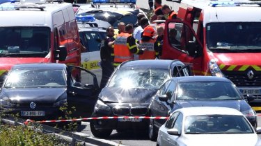 French security forces and emergency vehicles surround a car that authorities say was used in an attack on soldiers.