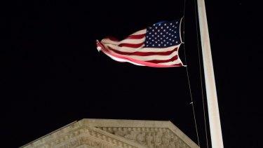 A US flag flies at half-staff in front of the US Supreme Court in Washington on Saturday evening.