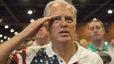 An attendee salutes as the pledge of allegiance is recited at a Donald Trump event.