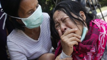 Family members of passengers on a military plane that crashed onto a residential area weep at a hospital in Medan, North Sumatra, in June, 2015.
