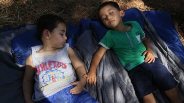 Abdul Rahman, 4, right, and his friend Miran Ali, both of Afghanistan, sleep on the grounds of a hospital on Leros, Greece.