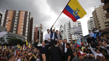 Presidential candidate Guillermo Lasso waves an Ecuadorean national flag in Quito on Tuesday. He has vowed to eject Julian Assange if he wins.