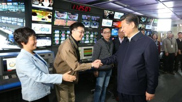 Propaganda offensive ... In this photo released by China's Xinhua News Agency, Chinese President Xi Jinping, right, shakes hands with staff members at the control room of China Central Television (CCTV) in Beijing on Friday.