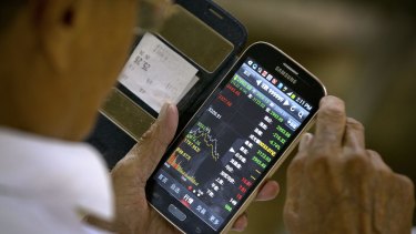 A Chinese investor uses his smartphone to monitor the slide in share prices last week.