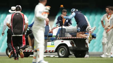John Orchard, at the rear, works on Phillip Hughes at the SCG. 