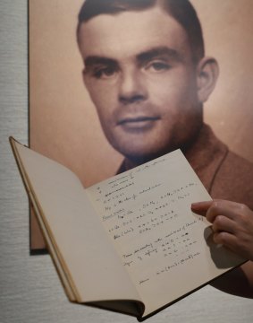 A page from the notebook of Alan Turing is displayed in front of his portrait at an auction preview in Hong Kong.