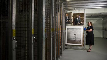 Art collection manager, Justine van Mourik with some of the hundreds of pieces of artwork stored beneath Parliament House.
