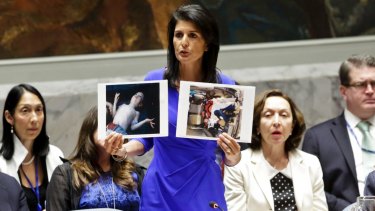 United States' Ambassador to the United Nations, Nikki Haley, holds pictures of Syrian victims.