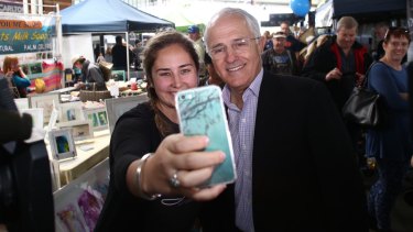Selfie-made man: The Prime Minister poses with a member of the public at Wyong farmers' markets in Saturday.