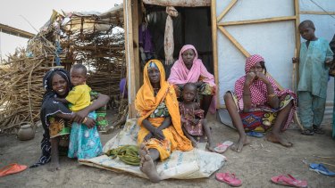 A family at Goni Kachallari in Maiduguri. They are one of 17,700 families in Borno who receive a monthly ration of oil, beans and millet.