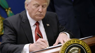 President Donald Trump signs an executive order in Washington.