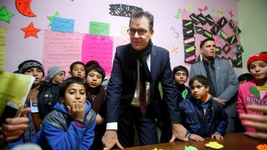 German Minister for Economic Co-operation and Development Gerd Mueller with Syrian refugee children during his visit to Baqaa Refugee Camp in Amman, Jordan, on Tuesday.