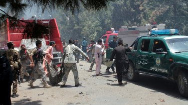 Afghans carry an injured man after the suicide car bombing in Helmand province.