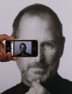 A photographer takes a picture with his own iPhone of a tribute to Apple Computer co-founder Steve Jobs  outside the Apple Store in Covent Garden in 2011 in London.