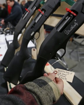 A man looks at the tag of a Weatherly shotgun for sale at a Rocky Mountain Gun Show in Sandy, Utah.