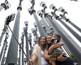 Marjorie Mabini takes a selfie with her niece Jaydah Mabini and son Jaren in front of the Urban Light installation at the Los Angeles County Museum of Art.