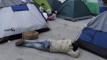A man sleeps on the ground in the Athens' port of Piraeus on Monday.
