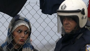 A woman looks at Greek police officer during a protest demanding the opening of the border between Greece and Macedonia on Sunday. 