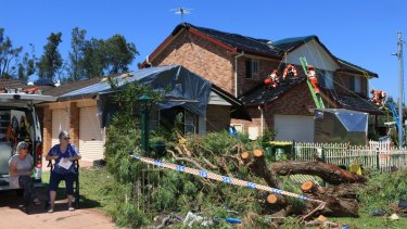Residents seek shade on Tasman St Kurnell as SES crews work to make a damaged home safe.